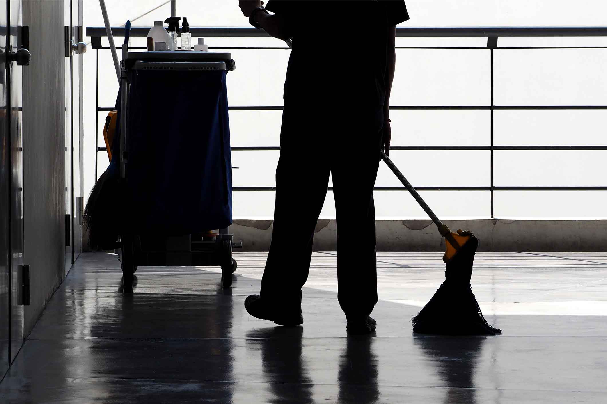 Silhouette-image-of-cleaning-service-people-sweeping-floor-with-mop-952104312_2121x1414
